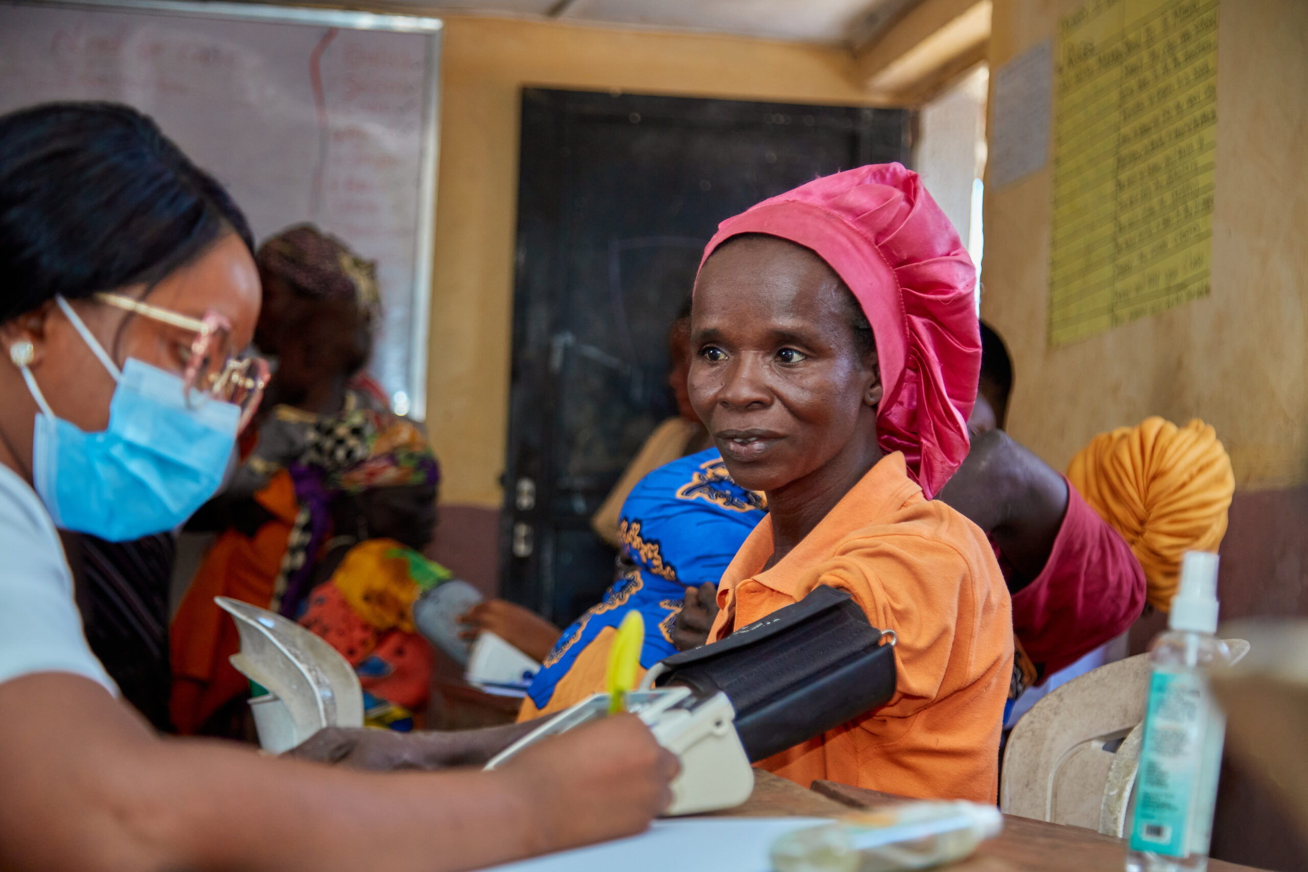 A picture of a healthcare worker checking the blood pressure of a resident of Kuchingoro IDP Camp